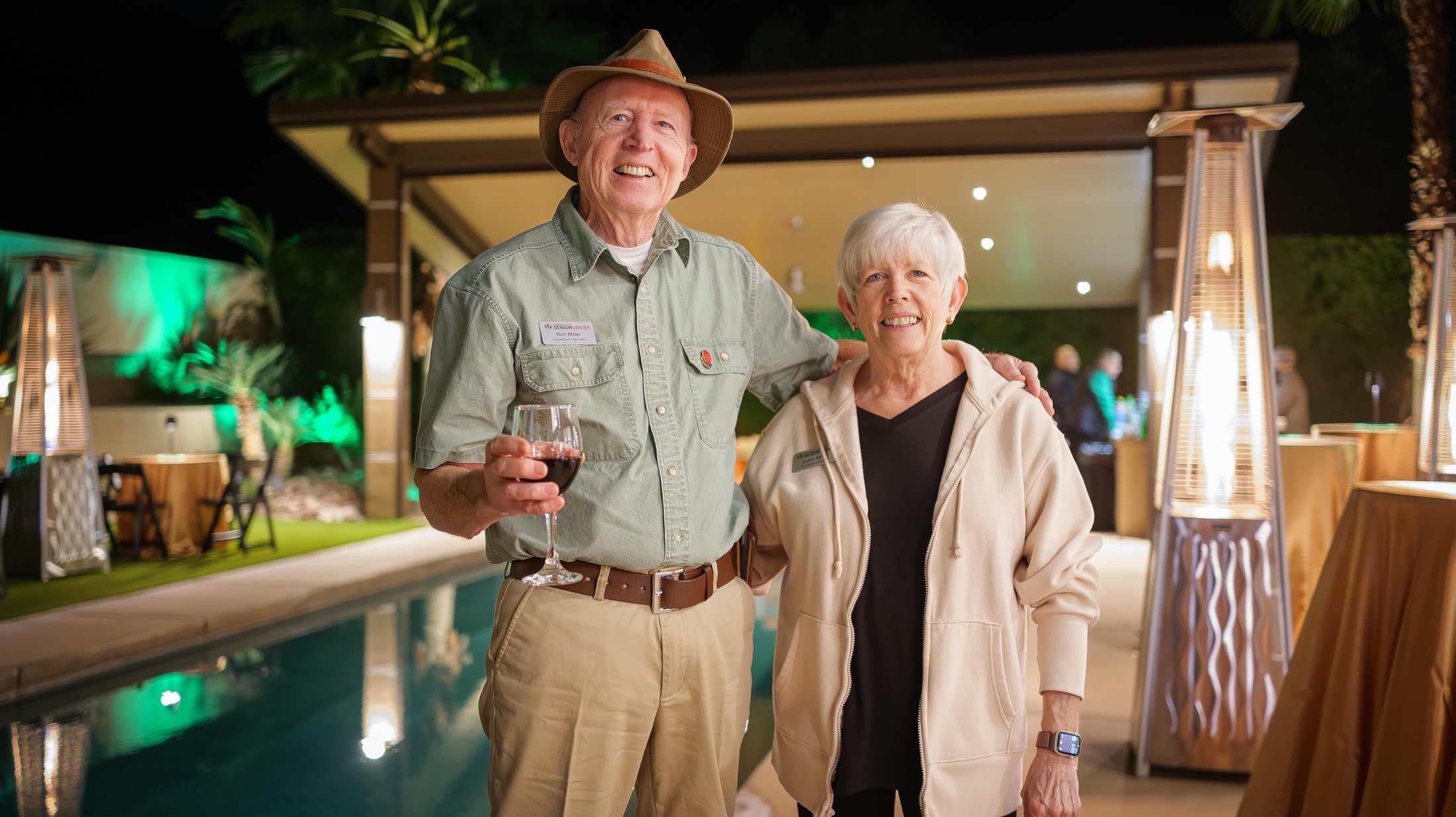Guests toasting with wine at an evening poolside event