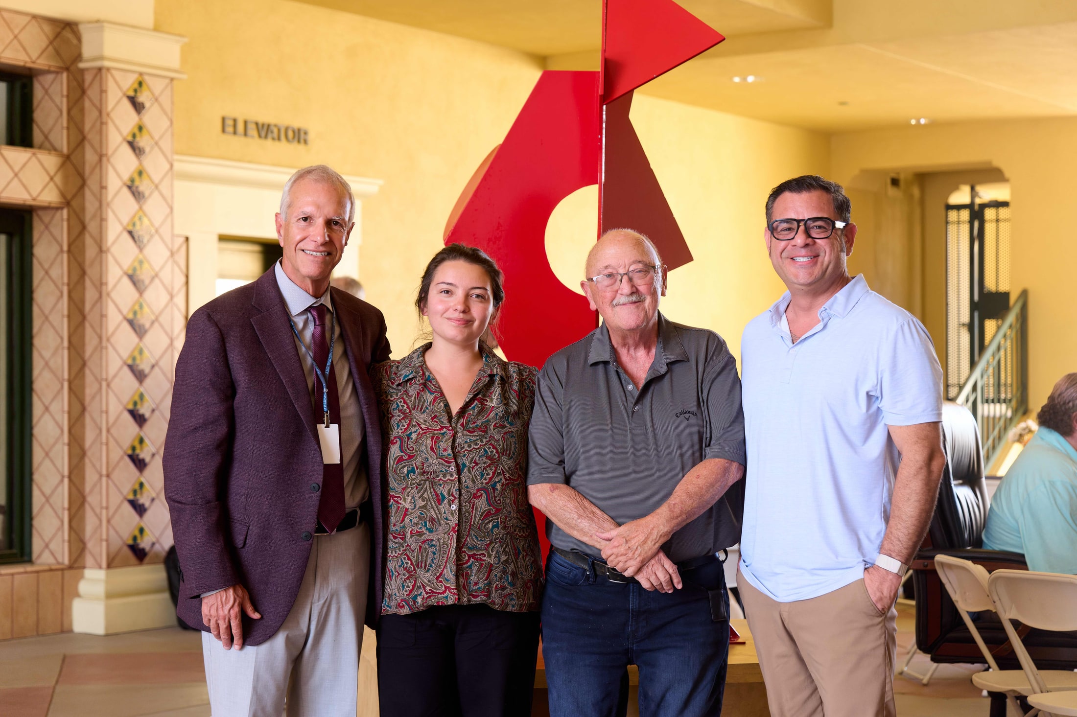 Group photo beside a red sculpture at a Cathedral City event