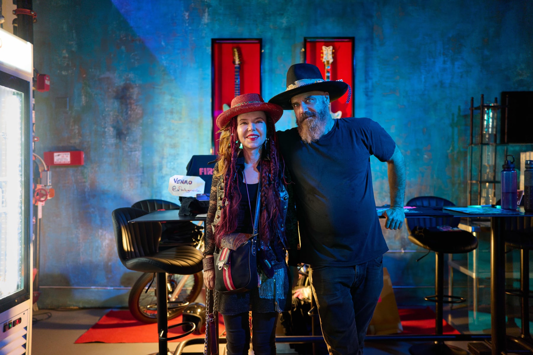Two guests in western hats beside the stage at The Firebug