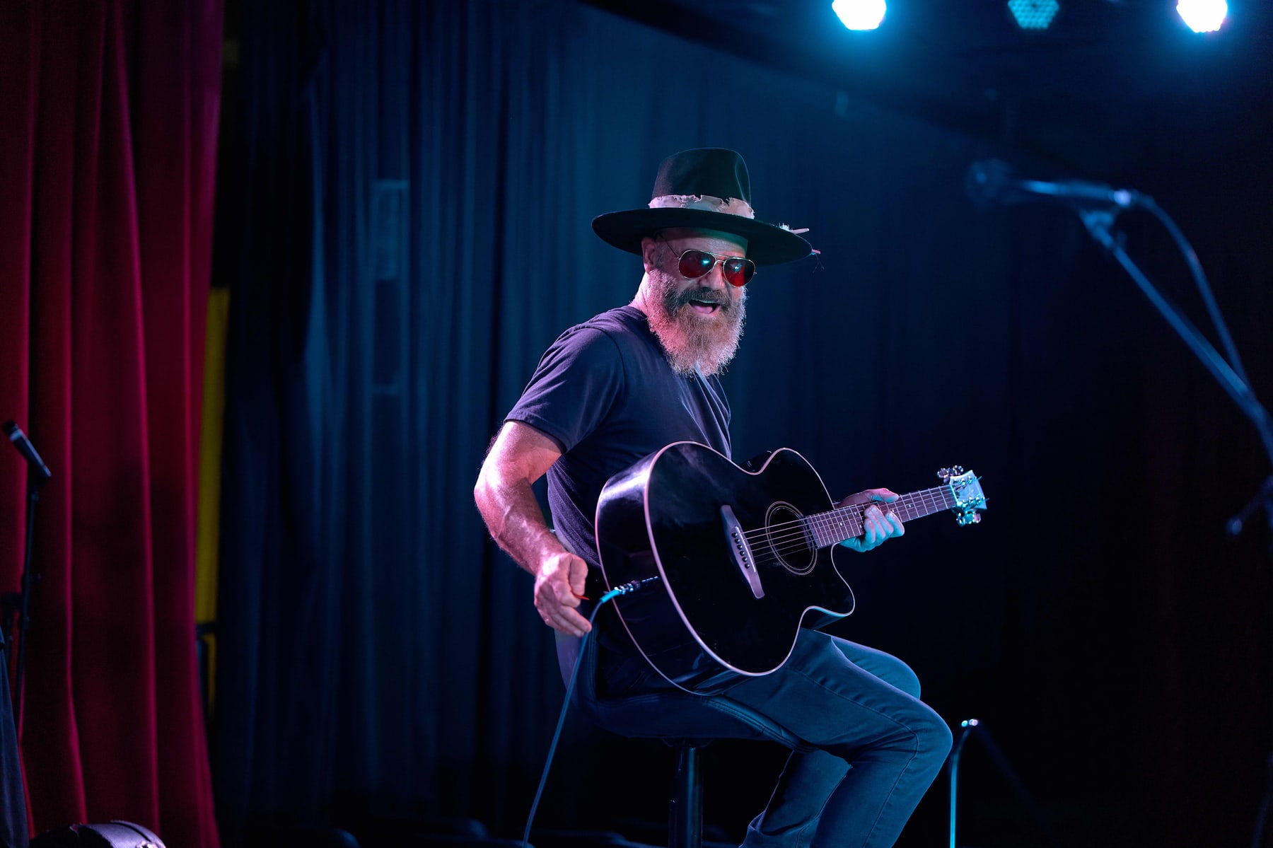 Guitarist performing on a blue lit stage at The Firebug