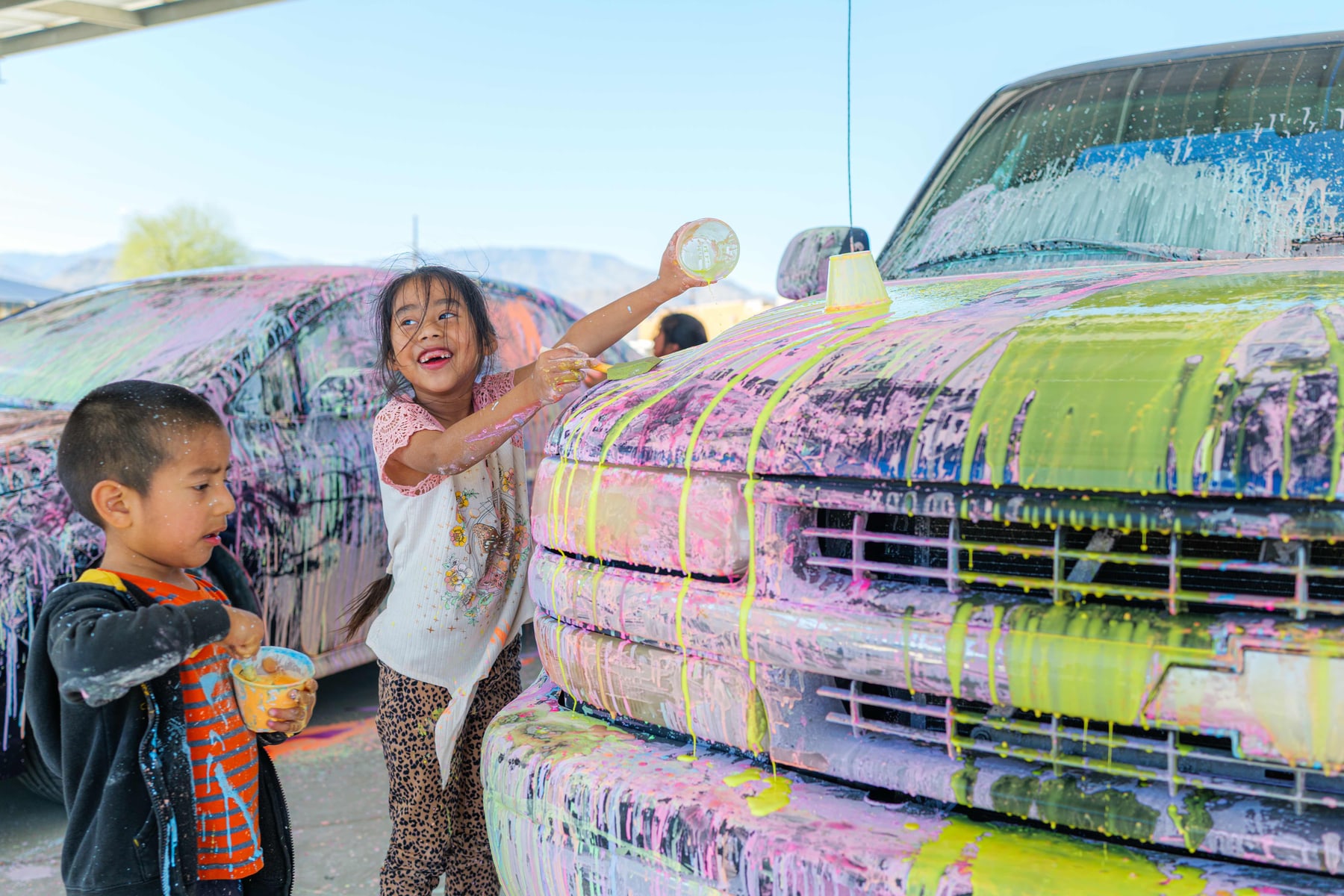 Children painting a truck at a Ganas community day