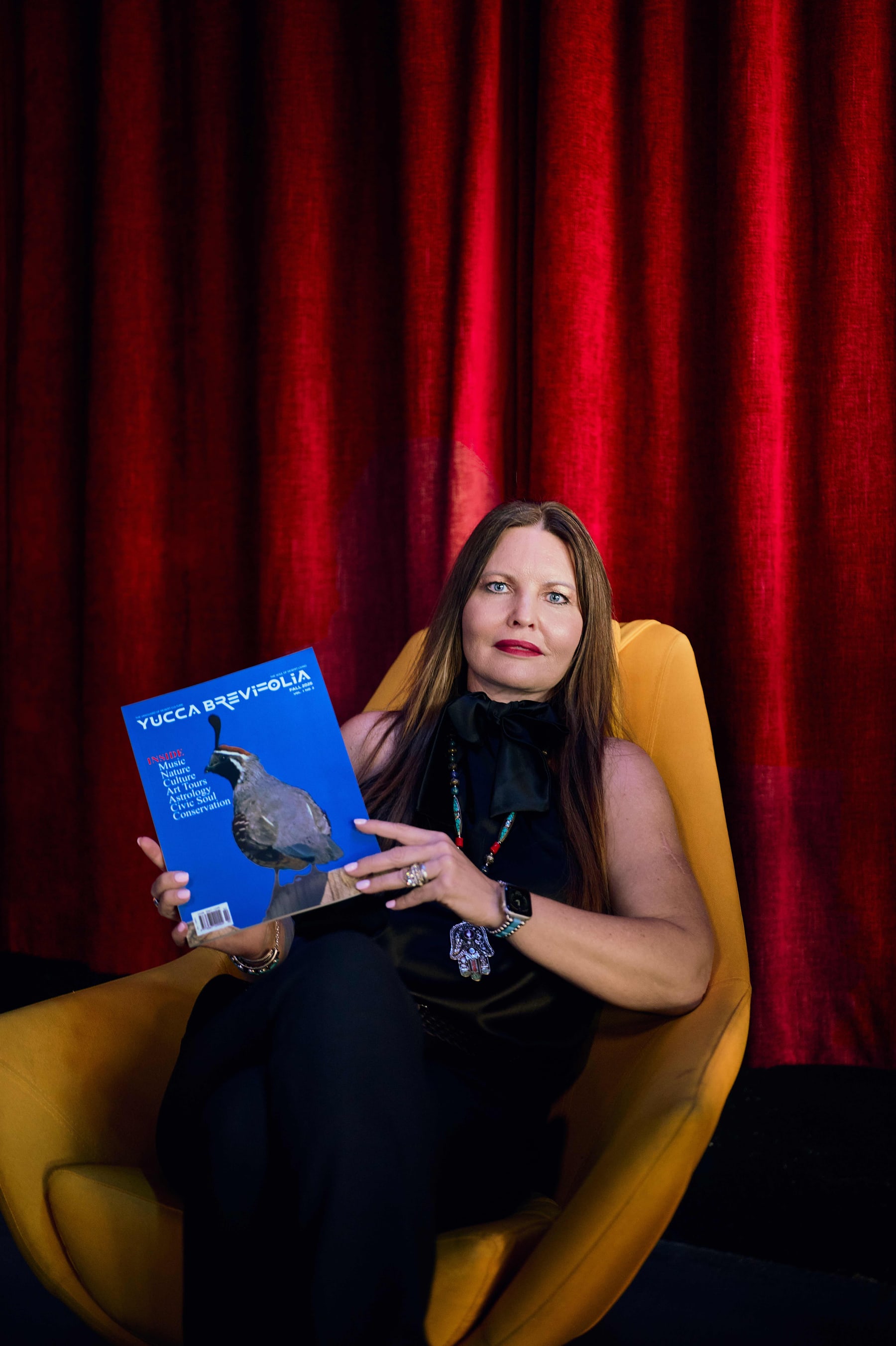 Lisa Schyck seated with a copy of Yucca Brevifolia