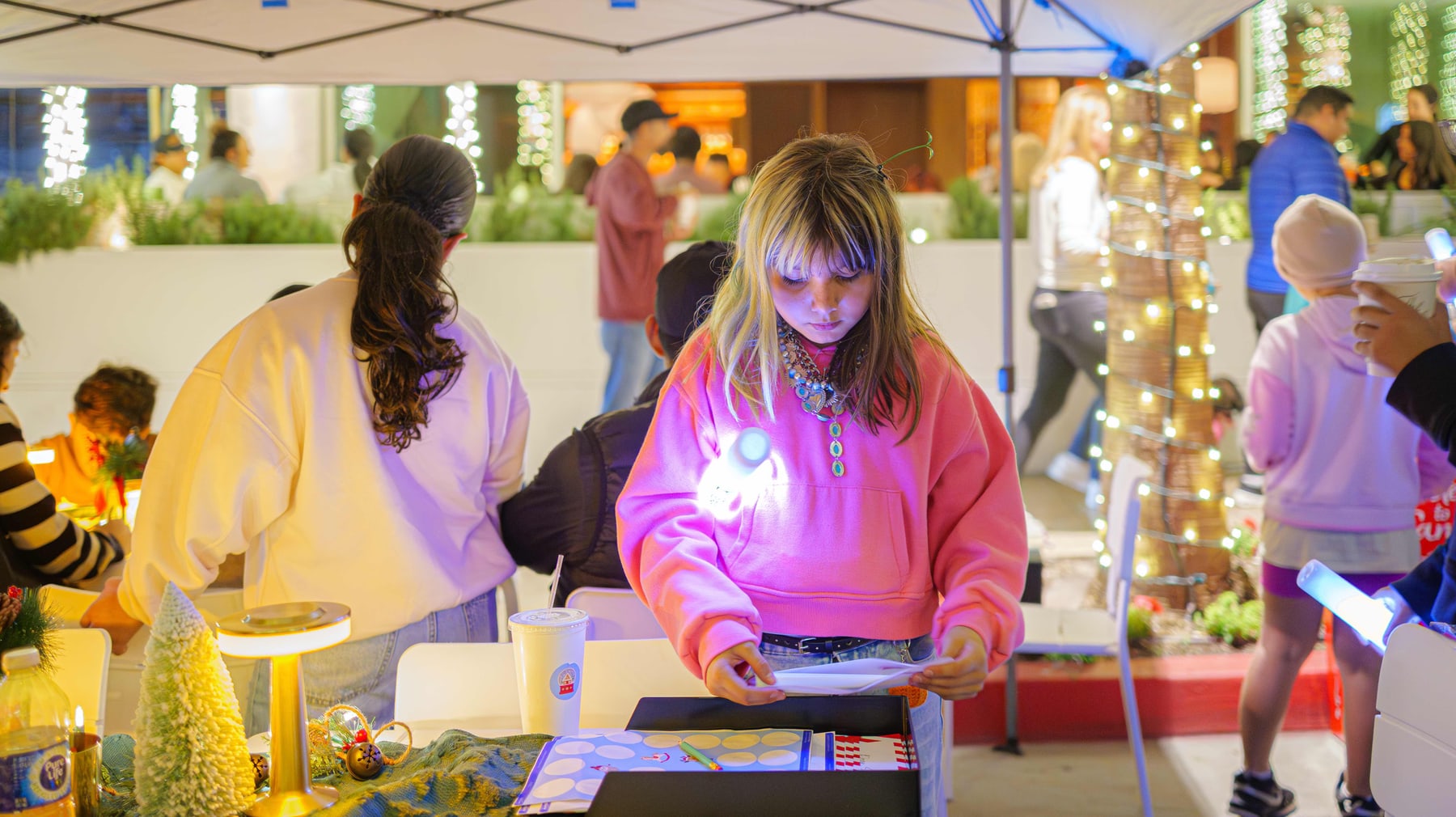 Children at the craft table under the lights