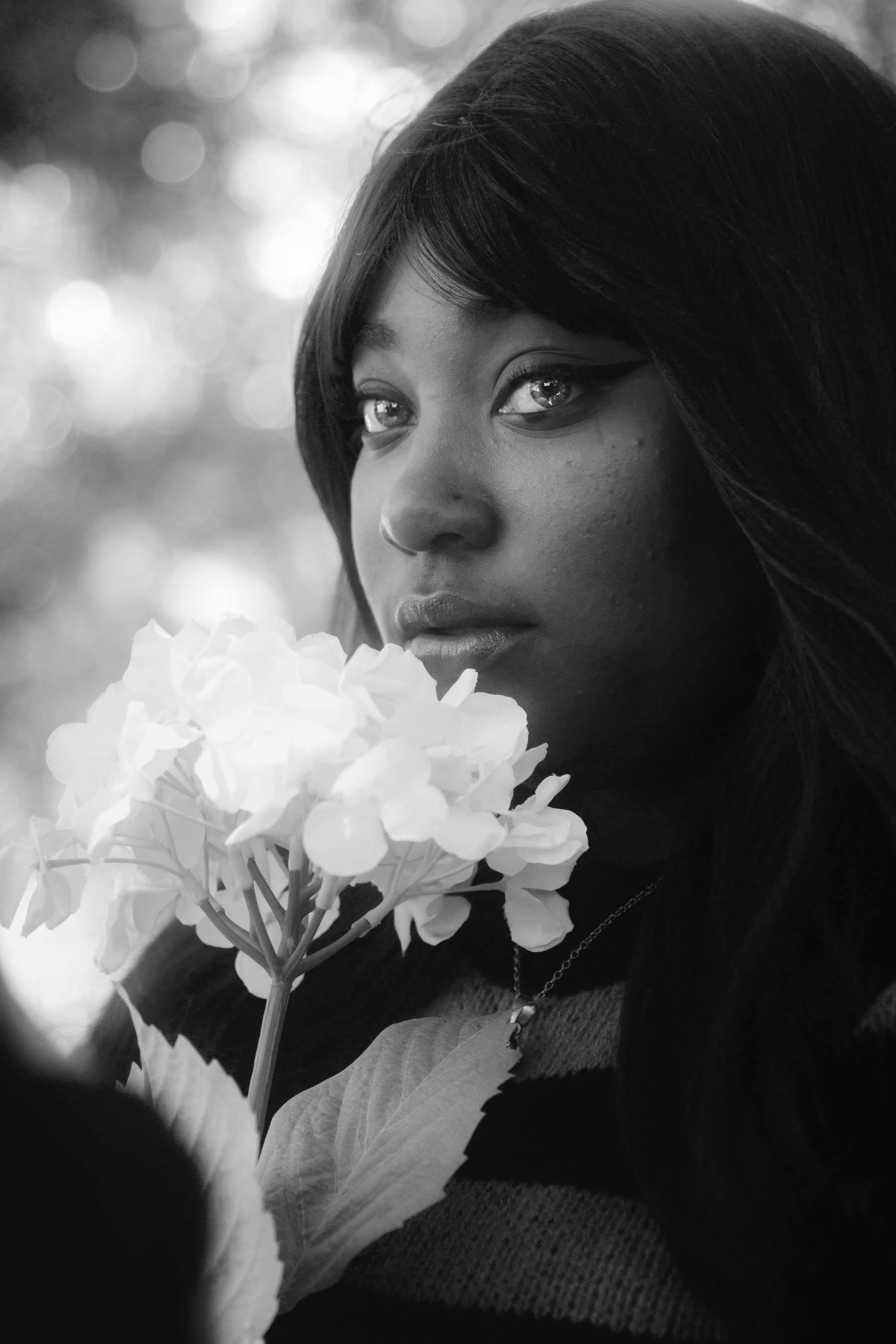 Black and white portrait of a young woman holding a flower