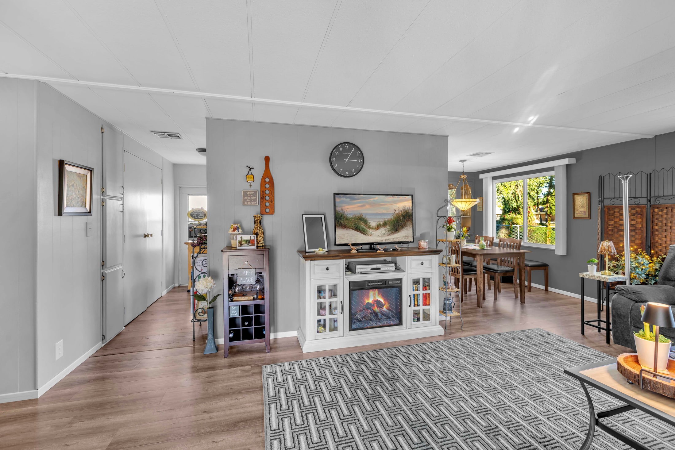 Living room with a fireplace, built in shelving and a dining area beyond