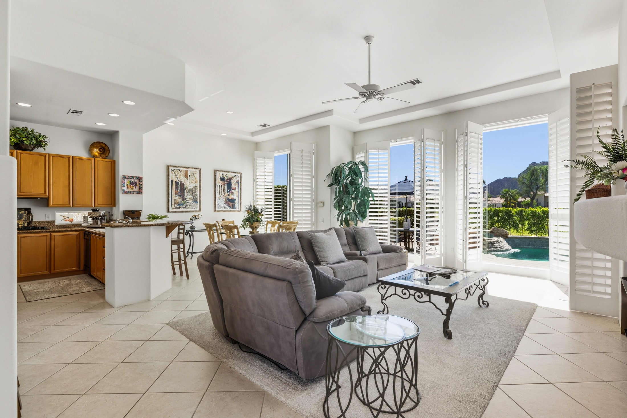 Bright living room opening onto a pool and mountain view