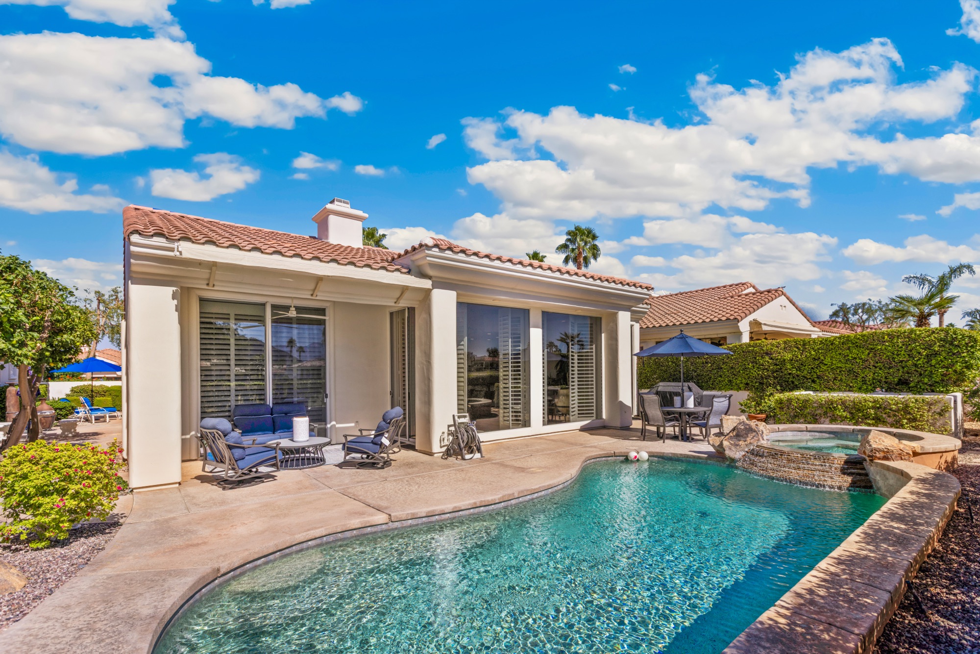 Backyard pool and patio under a blue sky